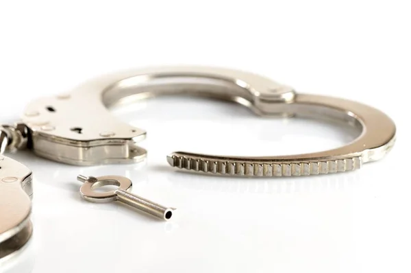 Metal handcuffs and keys isolated over white background — Stock Photo, Image