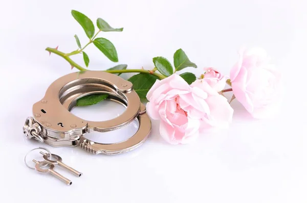 Fémbilincs, kulcsok és romantikus rózsaszín virág közeli felvétele — Stock Fotó