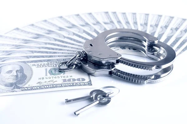 Close-up of metal handcuffs, keys and american dollars cash pack — Stock Photo, Image