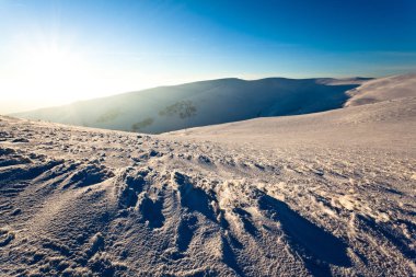 Panoramic sunset view of winter mountain hills covered with snow clipart