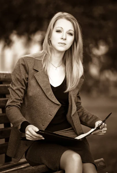 Portrait of young business lady sitting on bench with documents — Stock Photo, Image