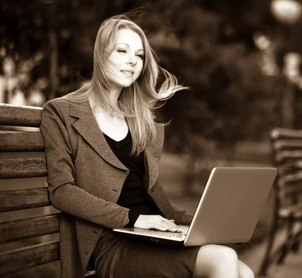 İş kadını elinde defterle parkta bankta oturuyor. — Stok fotoğraf