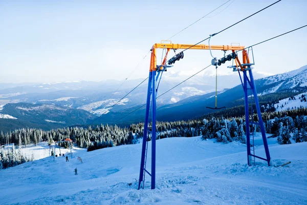 Manuele skilift en enkele skiërs met bergen en dal op de achtergrond — Stockfoto