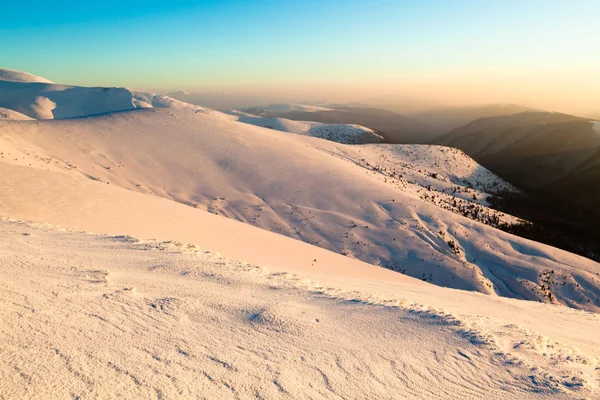 Vista panorâmica do pôr-do-sol das montanhas de inverno cobertas de neve — Fotografia de Stock