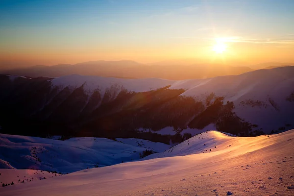 Vista panoramica sul tramonto delle colline montane invernali innevate — Foto Stock