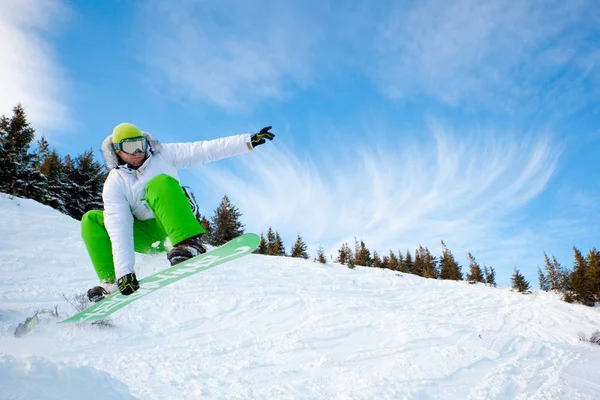 Jovem em sportswear jumping durante snowboard inverno em colinas — Fotografia de Stock