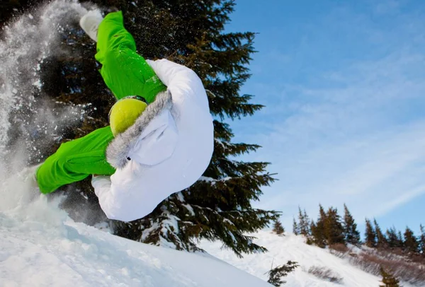 Giovane in abbigliamento sportivo che salta durante lo snowboard invernale — Foto Stock