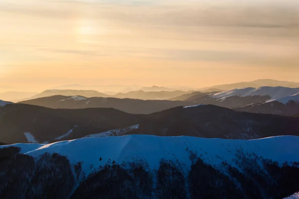 Pôr do sol sobre montanhas picos cobertos de neve no inverno dia claro — Fotografia de Stock