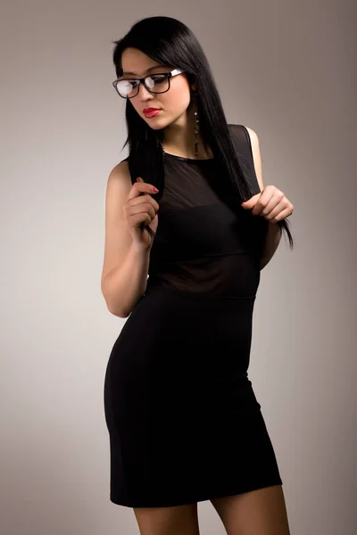 Молодая брюнетка в черной одежде и очках — стоковое фото