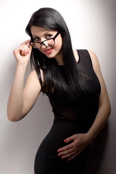 Joven morena vestida de negro y gafas — Foto de Stock