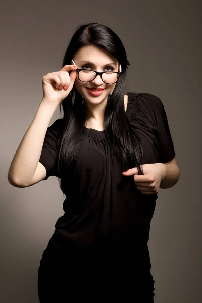 Νεαρή μελαχρινή γυναίκα με μαύρα ρούχα και γυαλιά — Φωτογραφία Αρχείου
