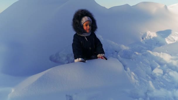 一个穿着深色西服的小女孩在冬天扔雪 — 图库视频影像