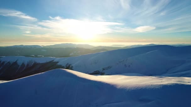 夕日に照らされた雪の山の上を飛ぶ — ストック動画