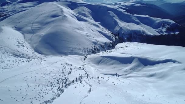 日に照らされたターコイズブルーの雪の山を飛ぶ — ストック動画