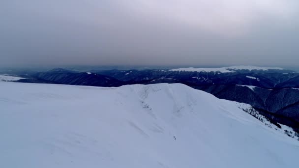 Vol au-dessus des montagnes enneigées illuminées par le soleil du soir 