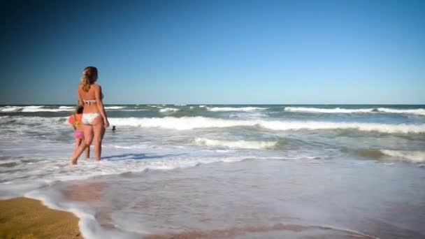 母と娘は海の波で楽しんでいます 子供たちと幸せな瞬間 — ストック動画