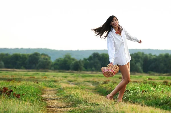 Mädchen tanzt auf Feld mit Korb in der Hand — Stockfoto