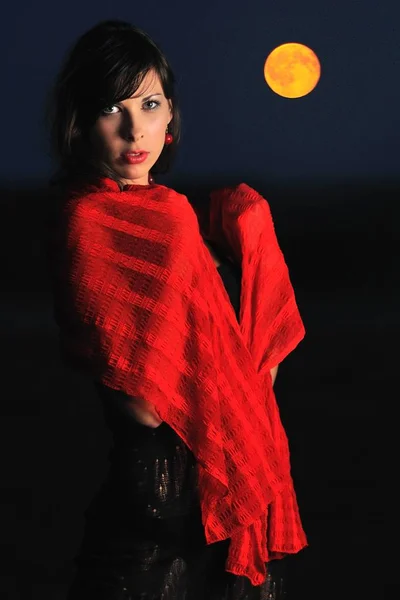 Дівчина позує з червоним шарфом на плечах — стокове фото