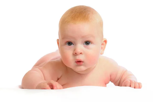 Lindo bebé se encuentra en una manta blanca —  Fotos de Stock