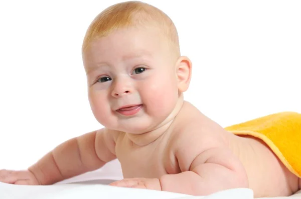 Lindo bebé se encuentra debajo de manta amarilla — Foto de Stock