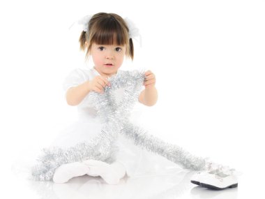 Elbiseli çocuk Noel süslemeleriyle oynuyor