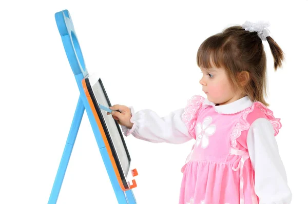 Baby girl carefully draws with chalk on blackboard — Stock Photo, Image