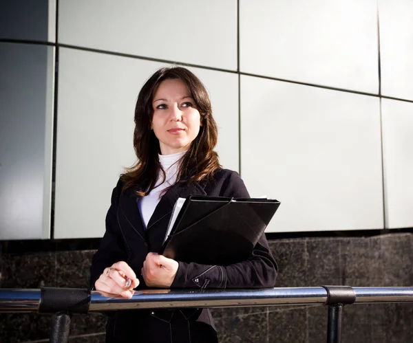 Businesswoman in suit holding papers in hands