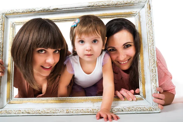 Дві дівчини і дитина тримають дерев'яну білу рамку — стокове фото