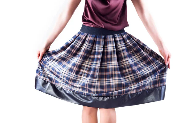 Фото девушки, держащей клетчатую юбку руками — стоковое фото