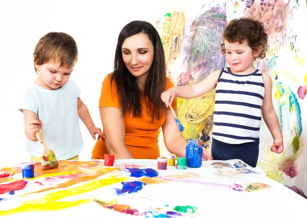 Donna e bambini che disegnano seduti a tavola Fotografia Stock