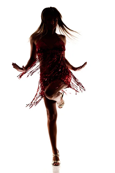 Dans eden ince, seksi kırmızı elbiseli güzel bir kadın silueti ve beyaz arka planda izole edilmiş yüksek topuklu ayakkabılar. — Stok fotoğraf