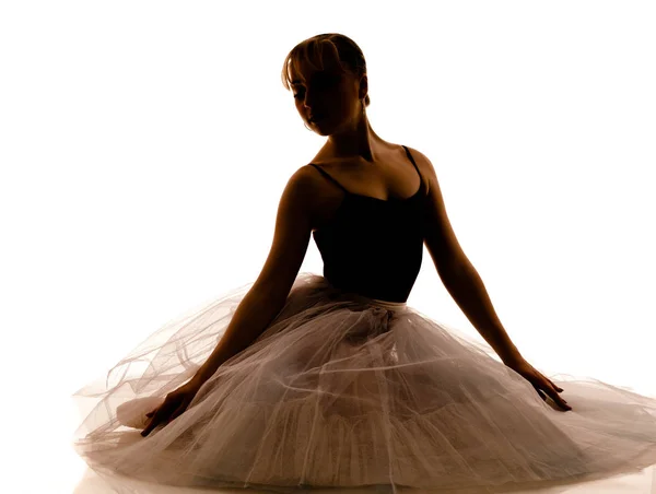 Силуэт молодой красивой балерины в белых пачках и пуантах в танцевальной позе — стоковое фото