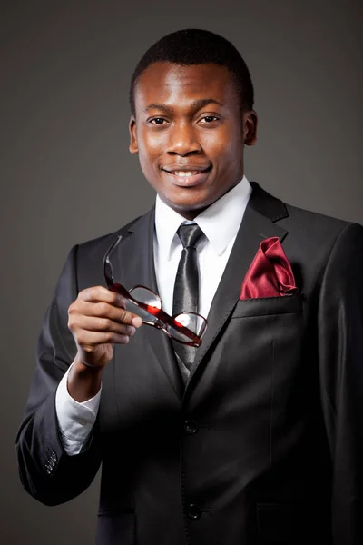 Joven hombre de negocios africano guapo en traje gris, camisa blanca, corbata y gafas —  Fotos de Stock
