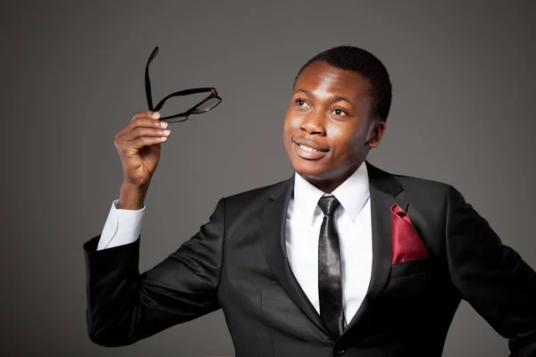 Joven hombre de negocios africano guapo en traje gris, camisa blanca, corbata y gafas —  Fotos de Stock