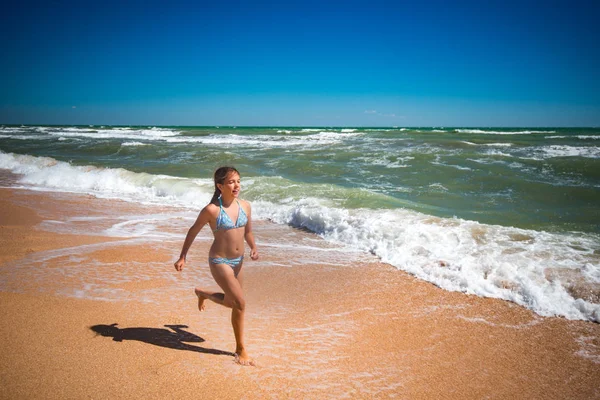 Gioiosa bambina attiva che salta sulle onde — Foto Stock