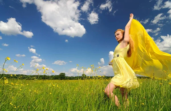 Mädchen posiert auf dem Feld mit einem Seidentuch in den Händen — Stockfoto