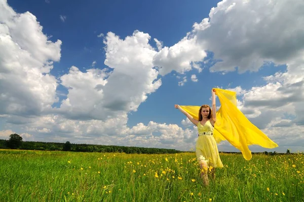 Femme posant dans un champ vert avec de la soie aérienne — Photo