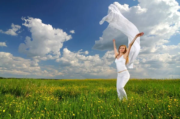 Kobieta pozuje na zielonym polu z jedwabiu airiness — Zdjęcie stockowe