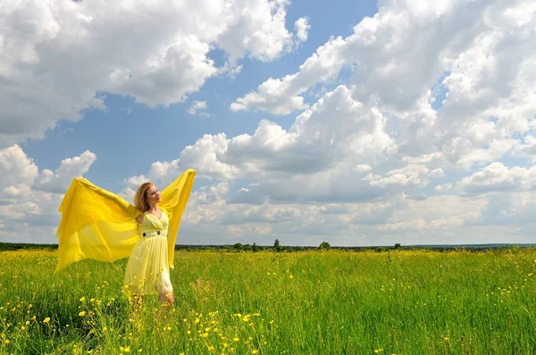 Girl in a green field posing with hands up — ストック写真