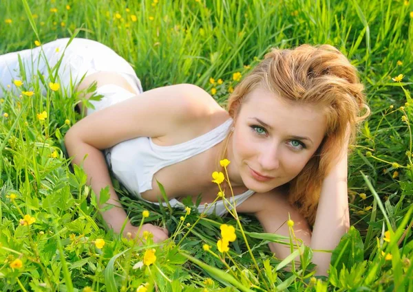 Cute girl lies on the grass and flowers — 스톡 사진