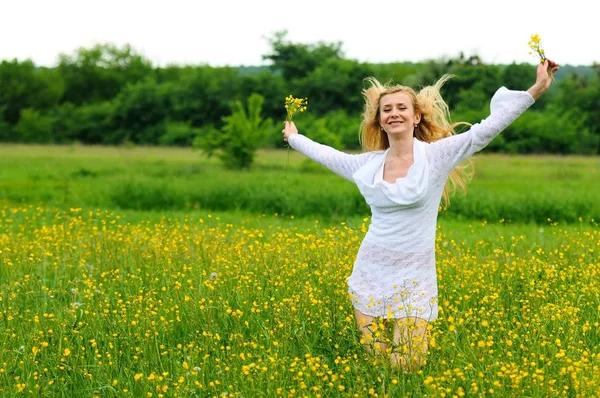 Gelukkig meisje in een geel bloemenveld — Stockfoto