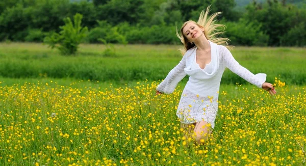 Счастливая девушка в желтом цветочном поле — стоковое фото