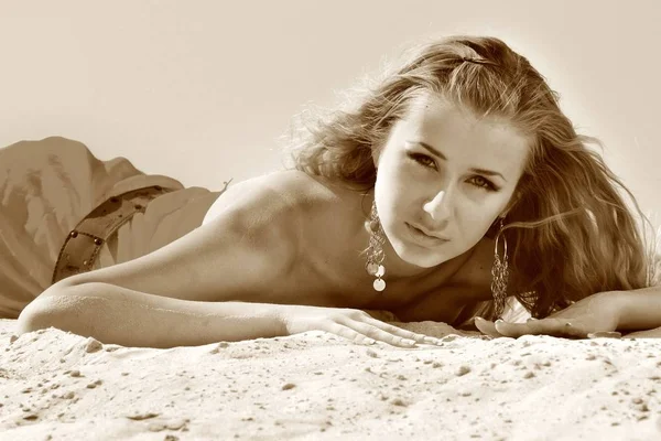 Mladý krásný blond štíhlý žena v plážovém oblečení ležící na písku — Stock fotografie