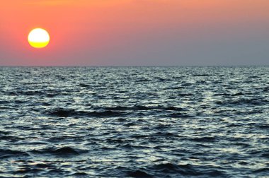 Kırım 'da Karadeniz' in dalgalı suları üzerinde güzel renkli gün batımı