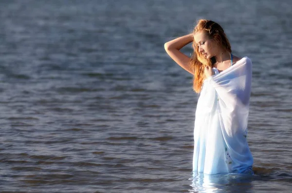 Mladá žena v bikinách stojící ve vodě na slunci — Stock fotografie