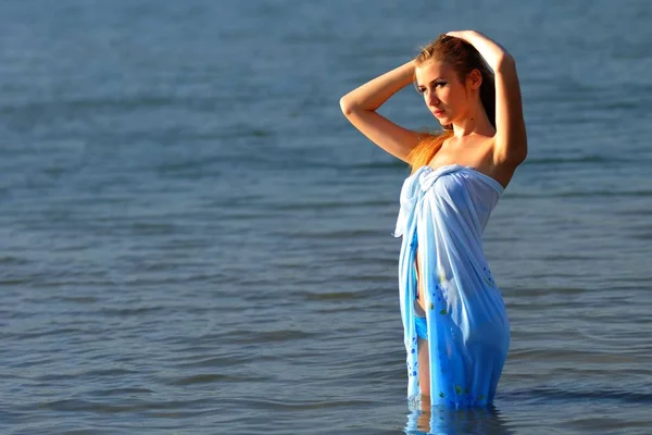 Young woman in bikini standing in water in sunshine — 스톡 사진
