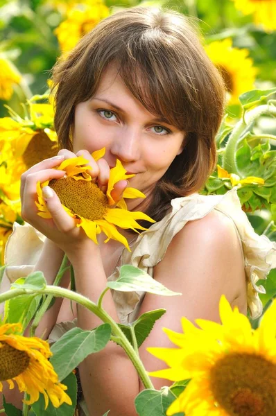 Çiçek tarlasında elinde ayçiçeğiyle bir kız — Stok fotoğraf