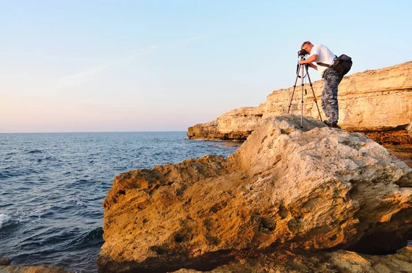 Omul stând pe stâncă și fotografiind cu trepied peste Marea Neagră — Fotografie, imagine de stoc