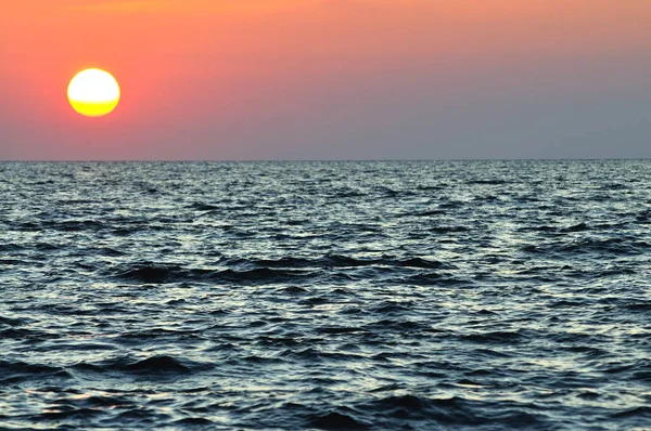 Vacker färgglad solnedgång över vågigt vatten i Svarta havet i Krim — Stockfoto