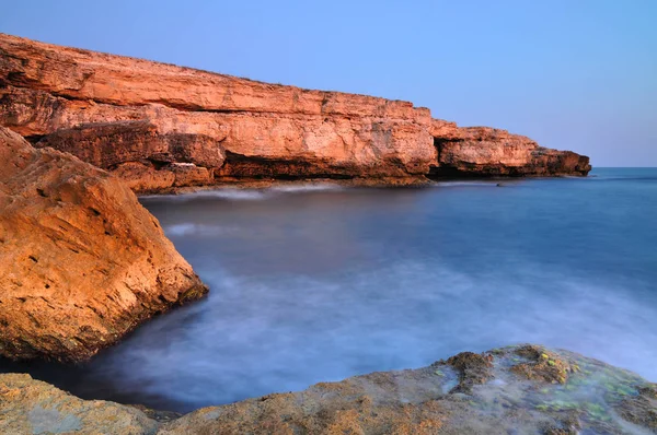 澄んだ青い海と青い空と黒海の海岸線の上の岩の上に立つ男 — ストック写真